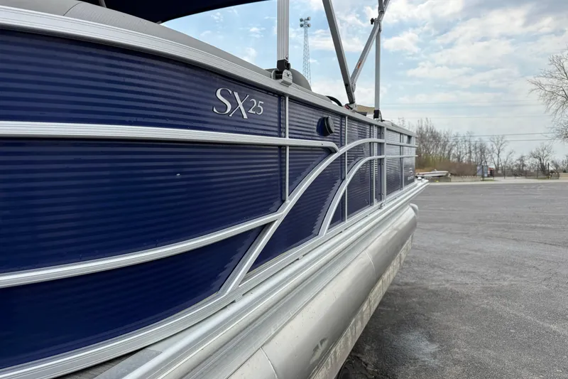 Slide: The Image of 2023 Bennington 25ssrc pontoon boat with blue exterior, parked on asphalt. - 18