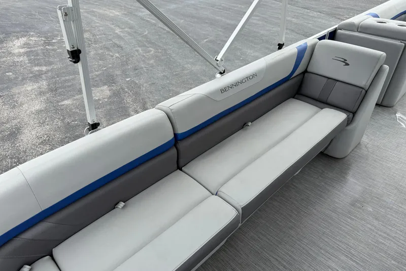 Slide: The Image of 2023 Bennington 25ssrc boat interior with gray and blue cushioned seating. - 19