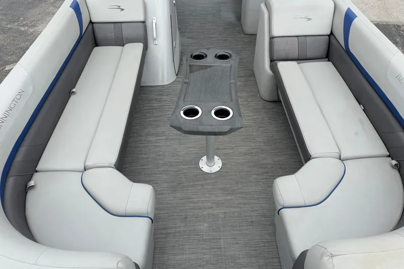 Slide: The Image of 2023 Bennington 25ssrc boat interior with gray seating and central table with cup holders. - 26