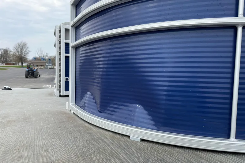 Slide: The Image of 2023 Bennington 25ssrc pontoon boat with blue paneling, parked outdoors. - 30