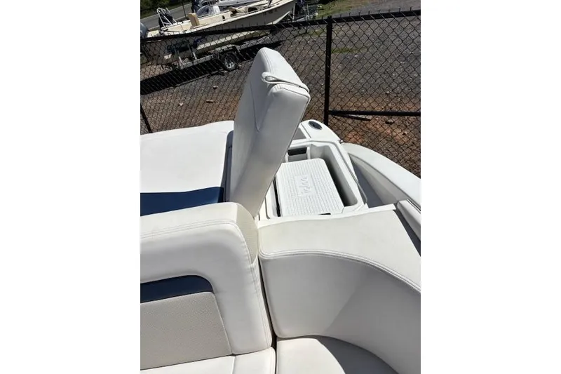 Slide: The Image of 2014 Chaparral 226 SSi boat interior with white seating and storage compartment. - 25