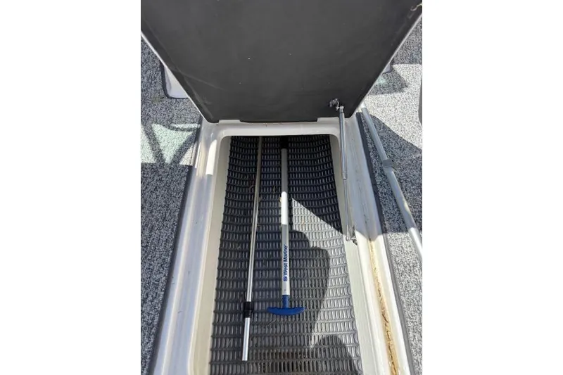 Slide: The Image of Open storage compartment in 2014 Chaparral 226 SSi boat with visible equipment. - 26