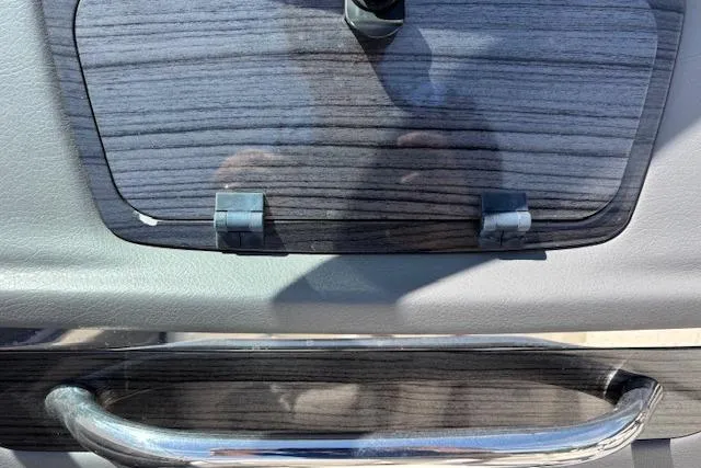 Slide: The Image of 2014 Chaparral 226 SSi boat dashboard with wood grain finish and chrome handle. - 27