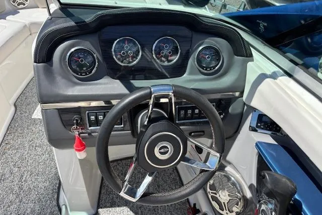 Slide: The Image of Steering wheel and dashboard of 2014 Chaparral 226 SSi boat, featuring gauges and controls. - 32