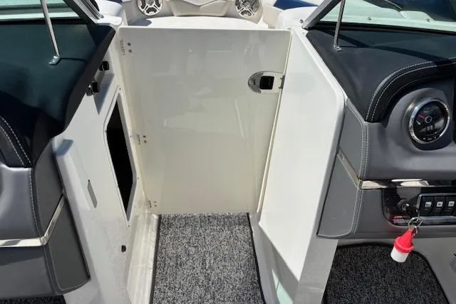 Slide: The Image of 2014 Chaparral 226 SSi boat interior with open storage compartment and dashboard view. - 33