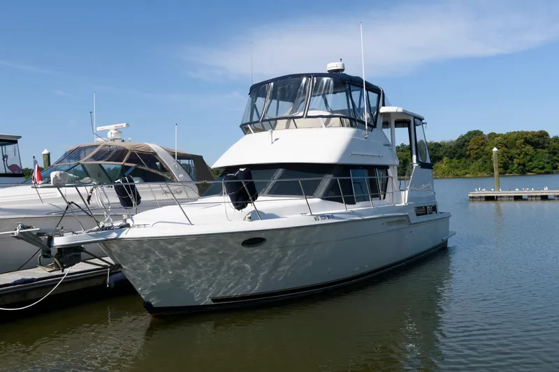 Slide: The Image of 1997 Carver 400 Cockpit Motor Yacht docked at marina. - 2