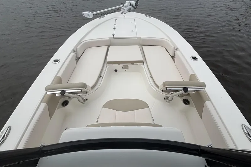 Slide: The Image of 2017 Robalo 246 Cayman boat interior with cushioned seating on calm water. - 12