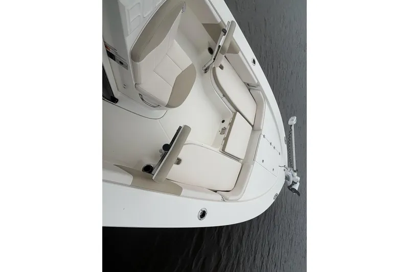 Slide: The Image of 2017 Robalo 246 Cayman boat interior with seating and storage on calm water. - 15