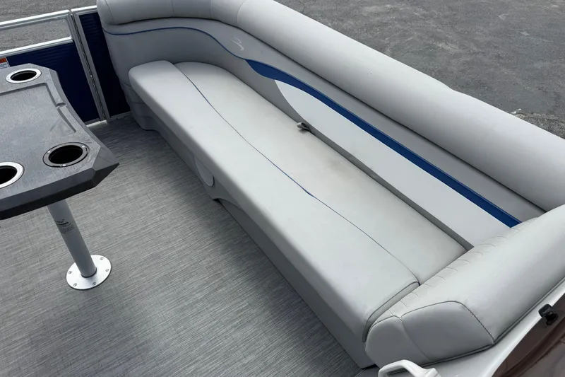 Slide: The Image of 2023 Bennington 24SSRC pontoon boat interior with gray seating and table with cup holders. - 23
