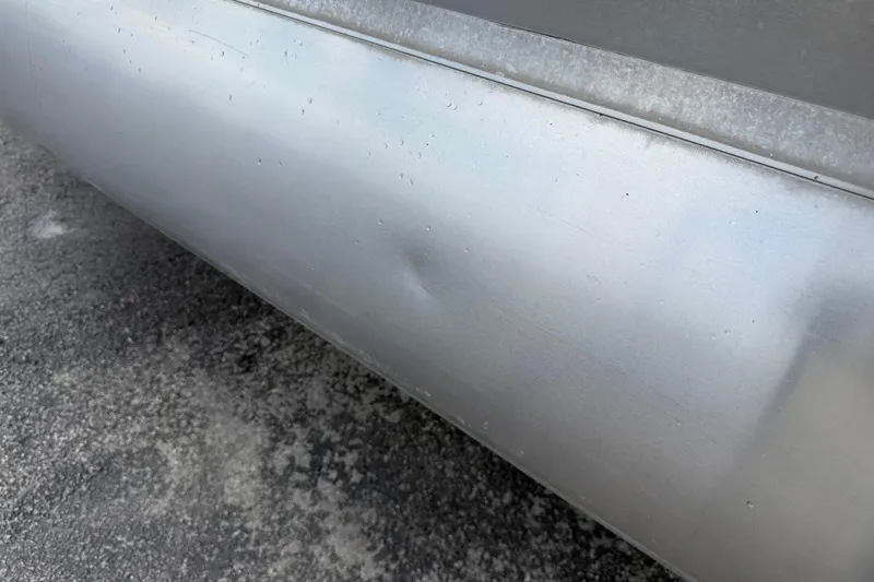 Slide: The Image of 2023 Bennington 24SSRC pontoon with a visible dent on the aluminum surface. - 25