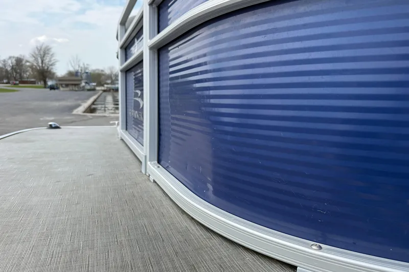 Slide: The Image of 2023 Bennington 24SSRC pontoon boat docked, showcasing sleek blue exterior design. - 27