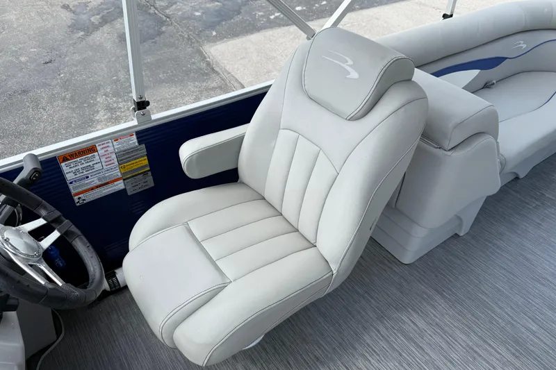 Slide: The Image of 2023 Bennington 24SSRC boat interior with plush captain's chair and steering wheel. - 28