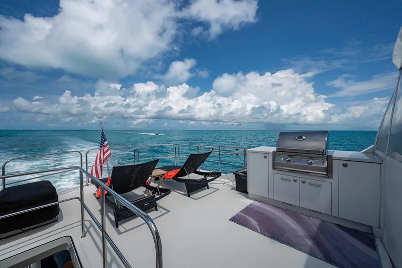 Slide: The Image of 2018 Cheoy Lee Bravo 78 Sport Motor Yacht deck with grill, lounge chairs, and ocean view. - 24