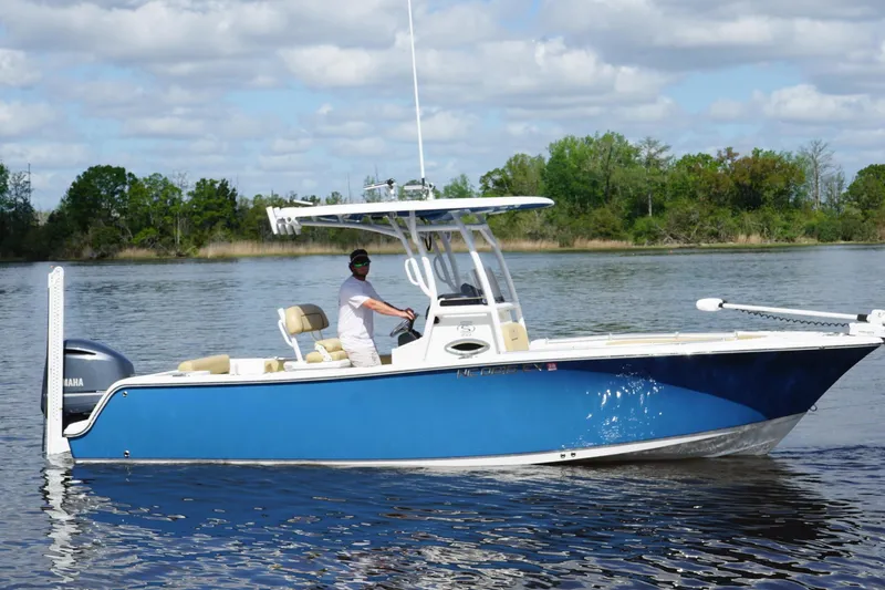 Slide: The Image of 2022 Sportsman Open 242 Center Console boat on calm water, with a person at the helm. - 10