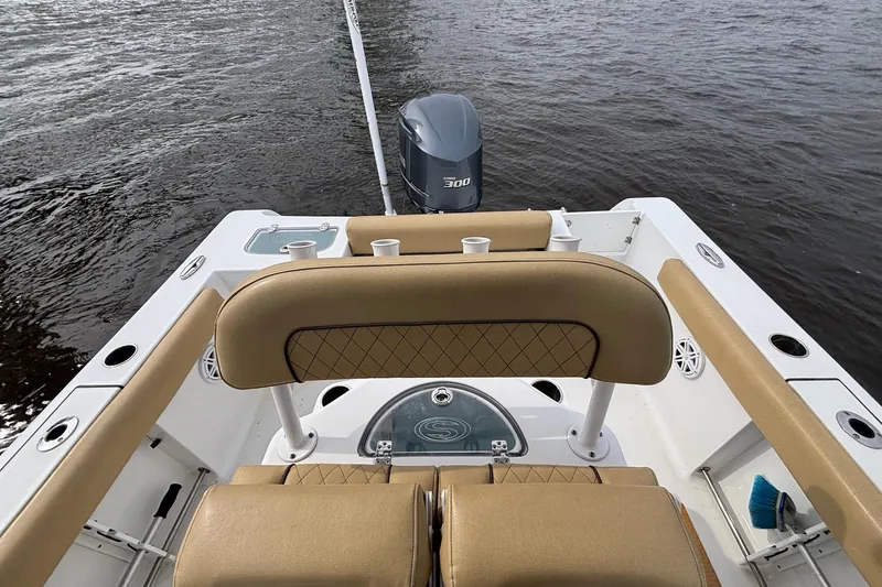 Slide: The Image of 2022 Sportsman Open 242 Center Console boat with tan seating and powerful outboard motor. - 13