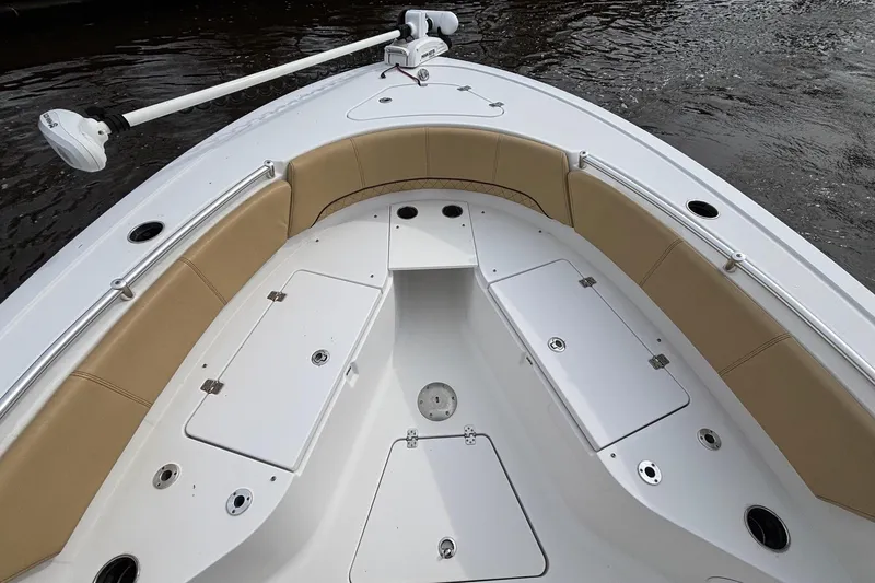 Slide: The Image of 2022 Sportsman Open 242 Center Console boat interior with tan seating and storage compartments. - 14