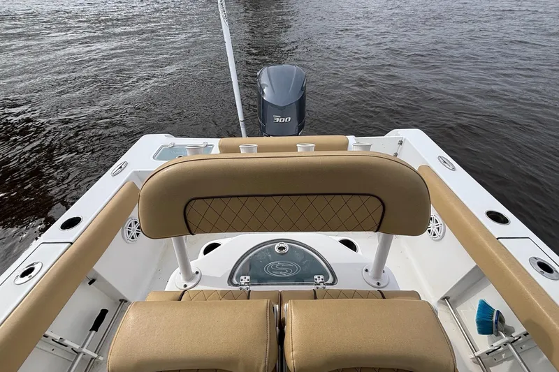 Slide: The Image of 2022 Sportsman Open 242 Center Console boat with tan seating and powerful outboard motor. - 16