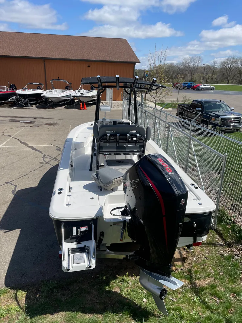 Slide: The Image of 2023 NauticStar 227 Bay boat with outboard motor in parking lot. - 10