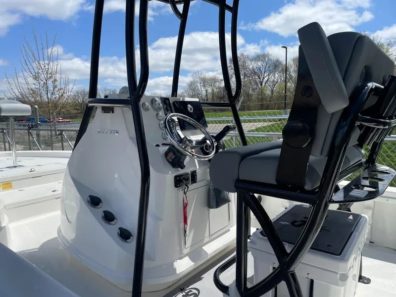 Slide: The Image of 2023 NauticStar 227 Bay boat console and seating area. - 12