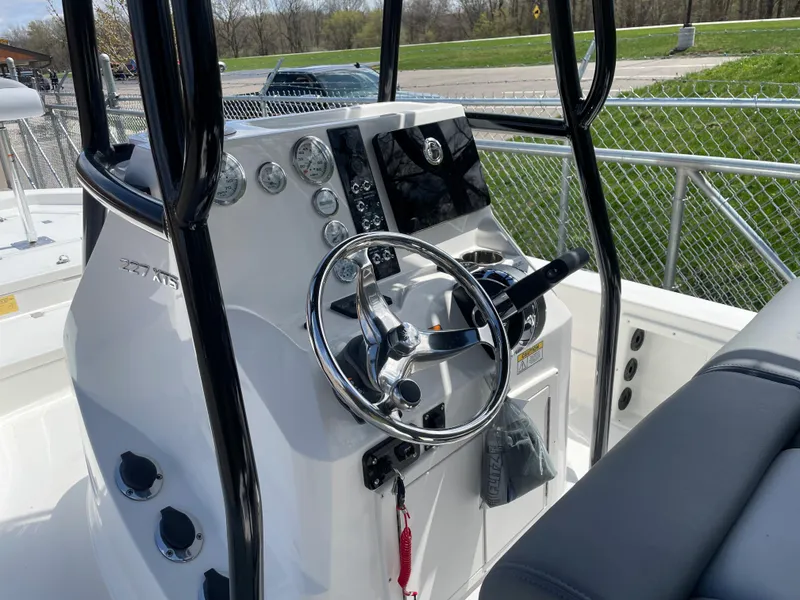 Slide: The Image of 2023 NauticStar 227 Bay boat console with steering wheel and navigation controls. - 13