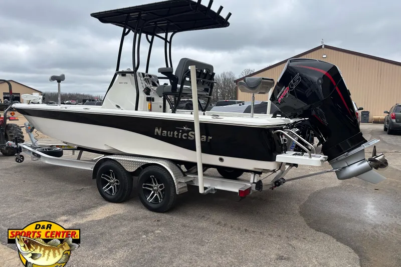 Slide: The Image of 2023 NauticStar 227 Bay boat on trailer, featuring powerful outboard motor. - 22