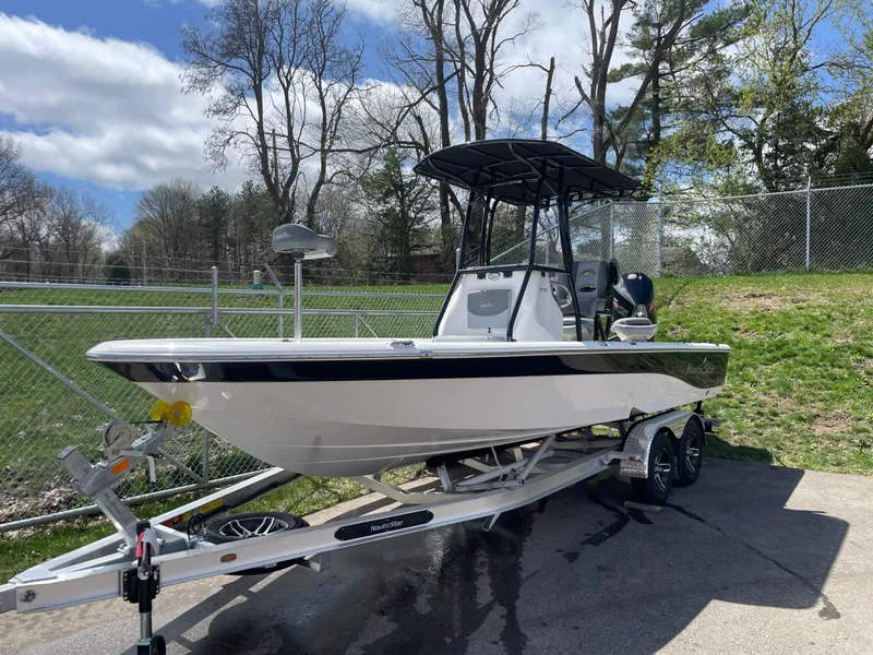Slide: The Image of 2023 NauticStar 227 Bay boat on trailer, parked outdoors. - 9