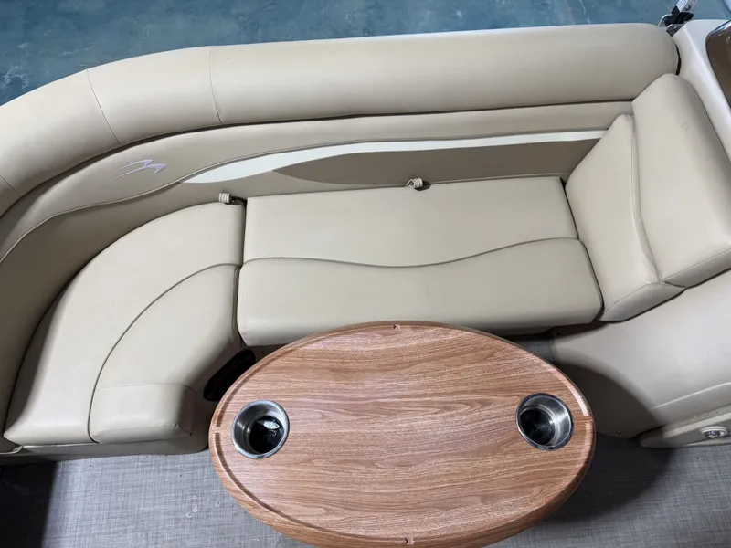 Slide: The Image of Interior of a 2016 Bennington 20SLX with beige seating and wooden table. - 11