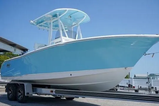 The Image of 2018 Sea Hunt Ultra 225 boat on water, American flag, sunny day. - 0