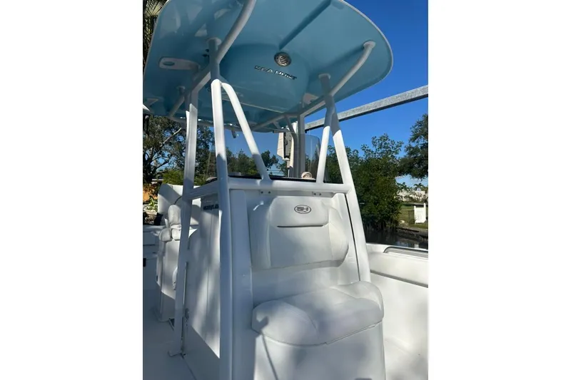 Slide: The Image of 2018 Sea Hunt Ultra 225 boat docked near waterfront home, clear blue sky. - 13