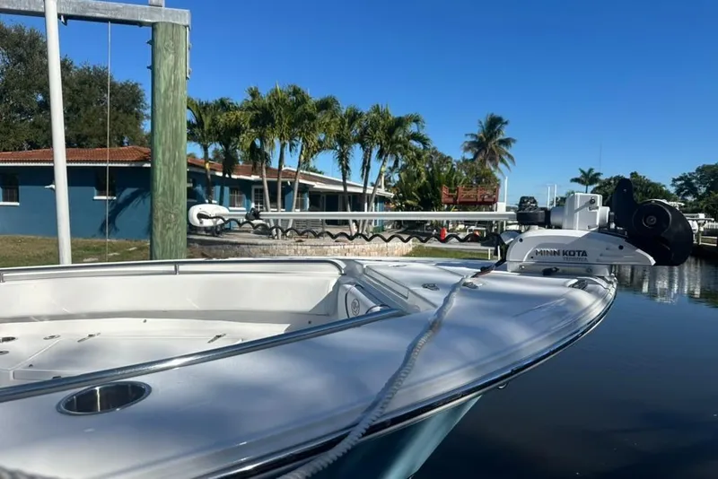Slide: The Image of 2018 Sea Hunt Ultra 225 boat docked by a waterfront home, featuring a Yamaha 200 engine. - 14