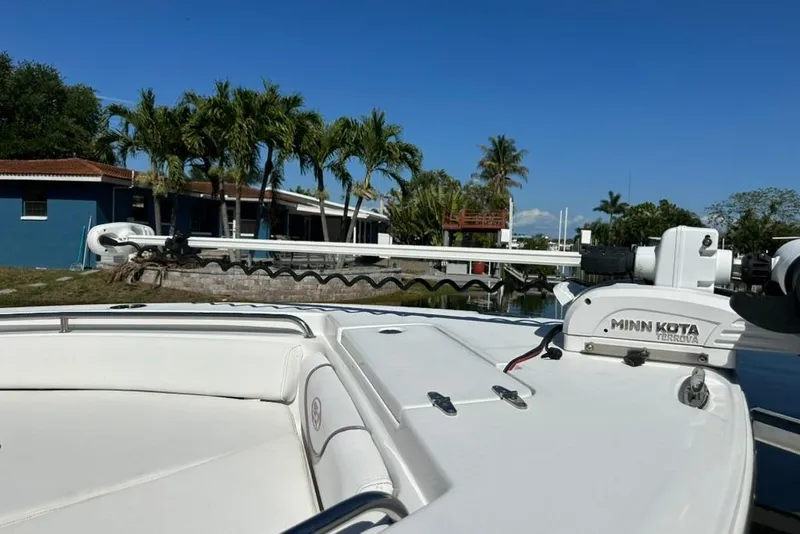 Slide: The Image of 2018 Sea Hunt Ultra 225 boat with Minn Kota Terrova motor, docked near palm trees. - 23