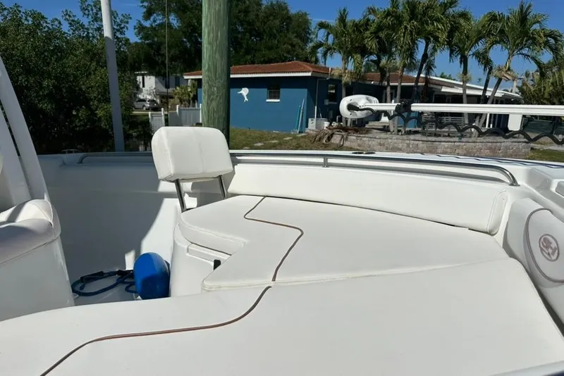 Slide: The Image of 2018 Sea Hunt Ultra 225 boat interior with white seating and outdoor background. - 26