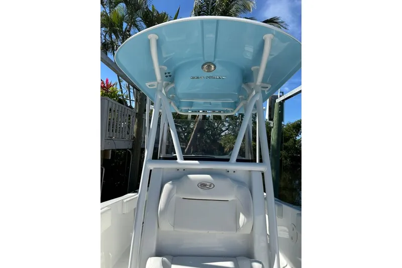 Slide: The Image of 2018 Sea Hunt Ultra 225 boat with blue T-top and white seating. - 31
