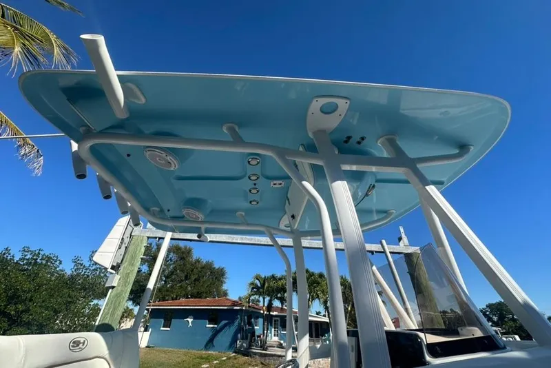 Slide: The Image of 2018 Sea Hunt Ultra 225 boat with blue T-top under clear sky. - 35