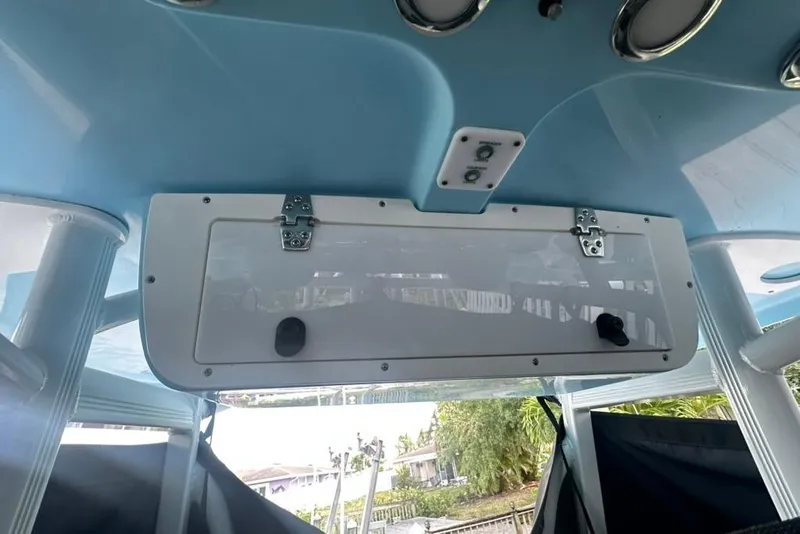 Slide: The Image of 2018 Sea Hunt Ultra 225 boat interior with storage compartment and blue ceiling. - 37