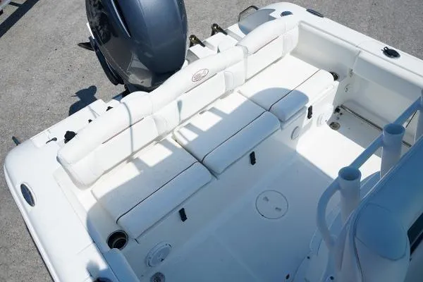 Slide: The Image of 2018 Sea Hunt Ultra 225 boat docked by waterfront home, clear blue sky. - 4