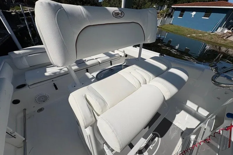 Slide: The Image of 2018 Sea Hunt Ultra 225 boat interior with white cushioned seating and helm. - 46