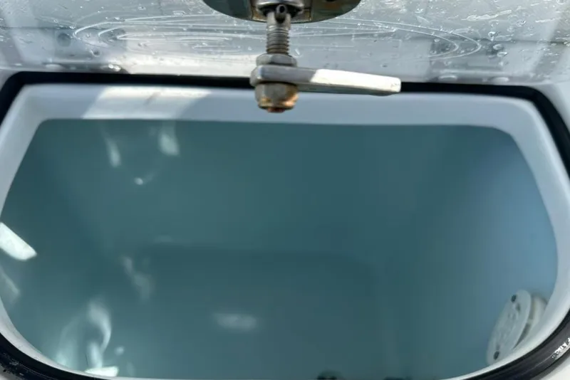 Slide: The Image of Livewell interior of a 2018 Sea Hunt Ultra 225 boat, featuring a water valve. - 49