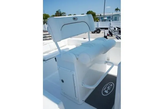 Slide: The Image of 2018 Sea Hunt Ultra 225 boat docked by a waterfront home under clear blue skies. - 5