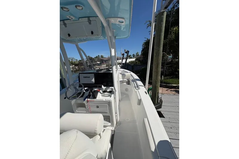 Slide: The Image of 2018 Sea Hunt Ultra 225 boat interior with steering wheel and Simrad display. - 54