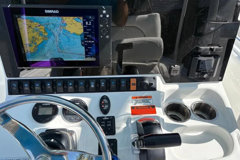 Slide: The Image of 2018 Sea Hunt Ultra 225 boat dashboard with Simrad navigation system and controls. - 57