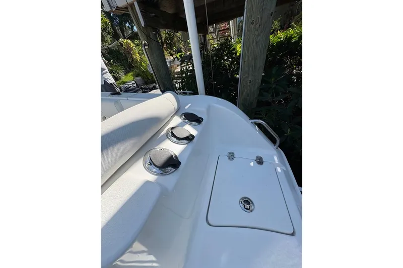 Slide: The Image of 2018 Sea Hunt Ultra 225 boat deck with rod holders and storage compartment. - 69