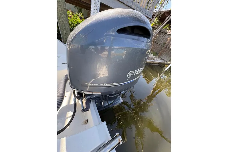 Slide: The Image of Outboard motor on a 2018 Sea Hunt Ultra 225 boat, docked by water. - 70