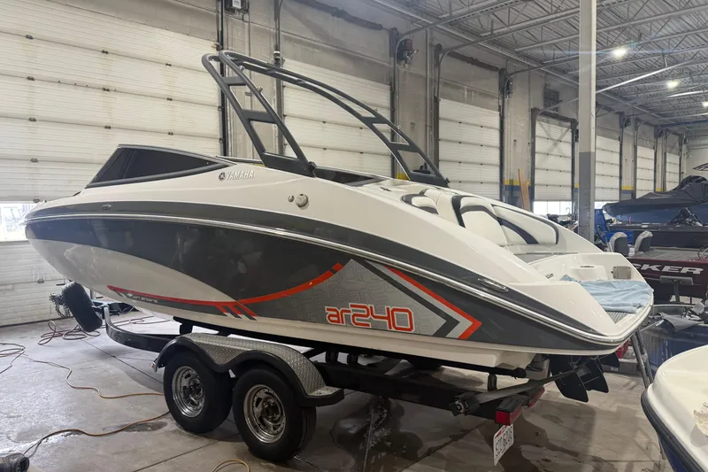 The Image of 2015 Yamaha Boats AR240 HO in a garage, on a trailer, side view. - 0
