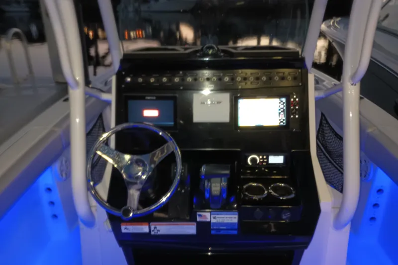 Slide: The Image of 2019 Wellcraft 242 Scarab Offshore boat dashboard with illuminated controls and steering wheel. - 17
