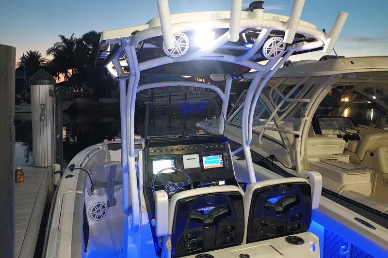 Slide: The Image of 2019 Wellcraft 242 Scarab Offshore boat with illuminated cockpit at sunset. - 20