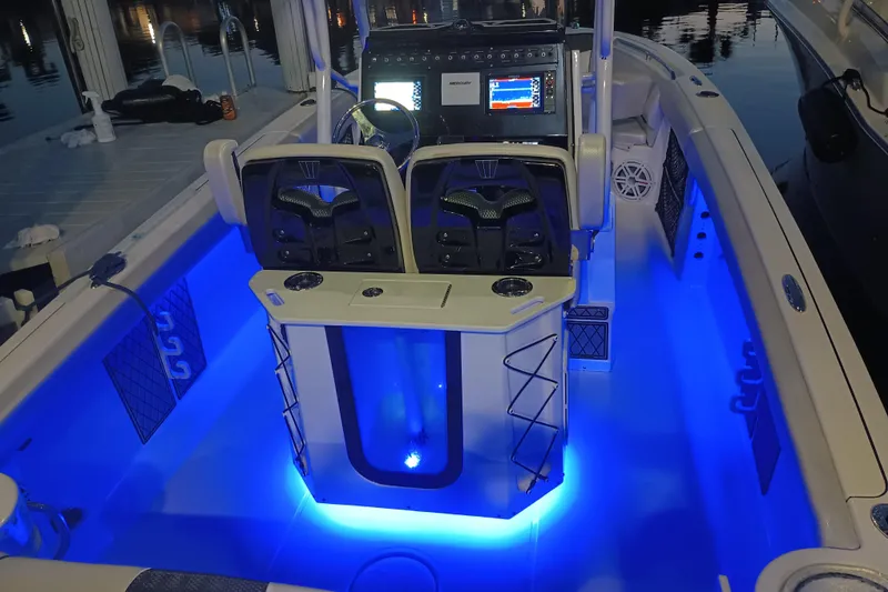 Slide: The Image of 2019 Wellcraft 242 Scarab Offshore boat interior with blue LED lighting and modern dashboard. - 26