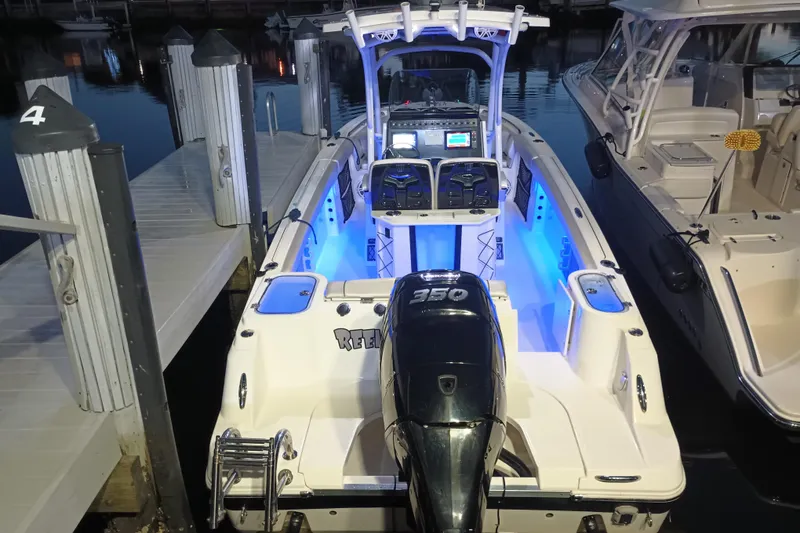 Slide: The Image of 2019 Wellcraft 242 Scarab Offshore boat docked at marina, surrounded by other vessels. - 3