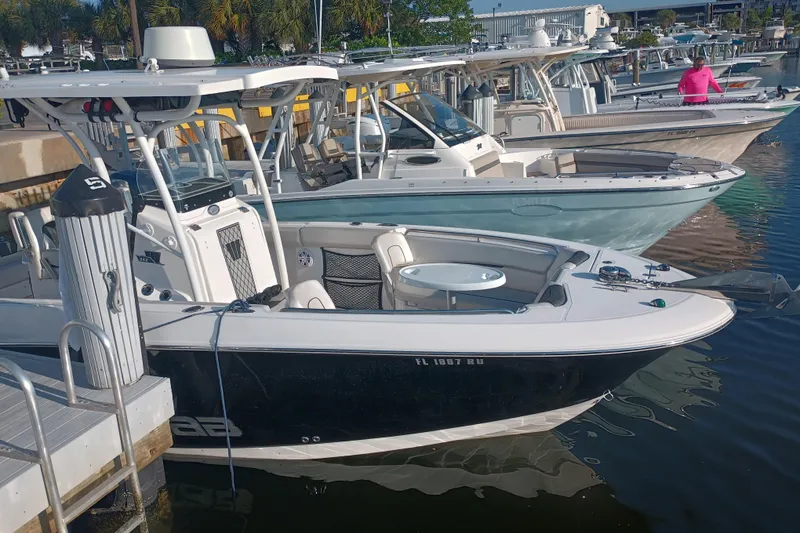 Slide: The Image of 2019 Wellcraft 242 Scarab Offshore boat docked, showcasing helm and seating area. - 4