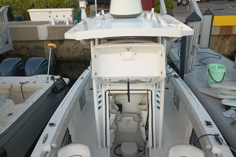 Slide: The Image of 2019 Wellcraft 242 Scarab Offshore boat docked, featuring dual engines and spacious deck. - 5